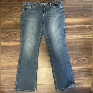 Low rise women’s flare jeans with gems and a design of a cross on back pocket